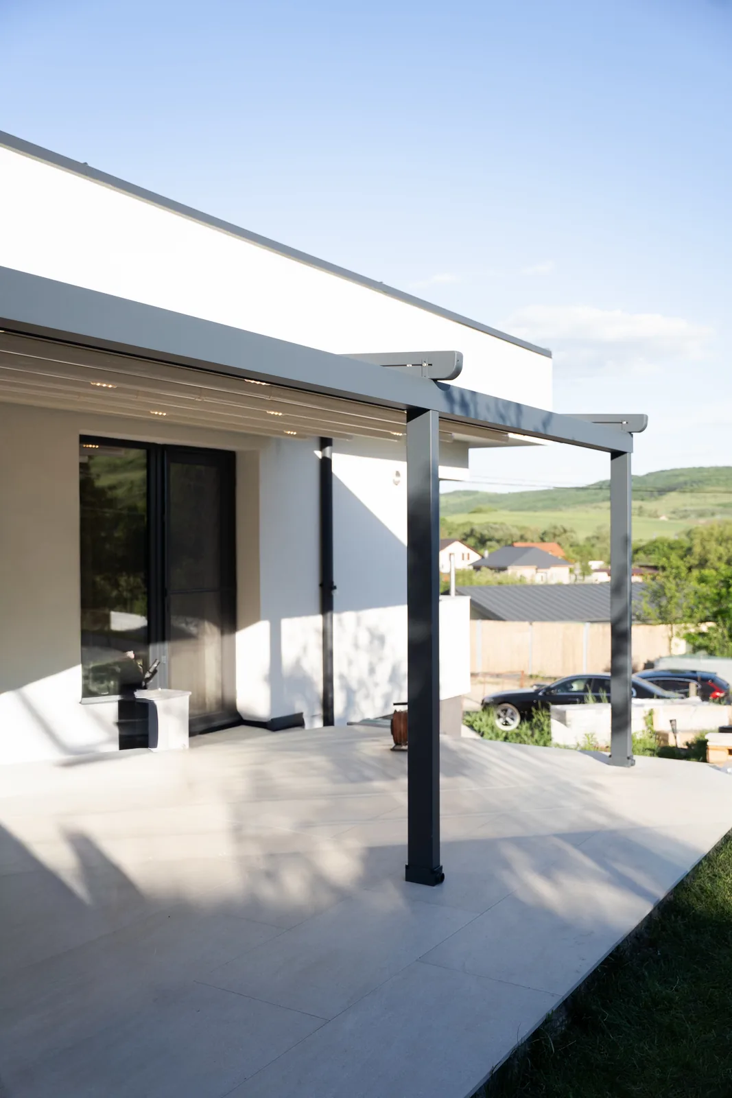 Terasă acoperită cu pergolă retractabilă PVC HEXANN, văzută din lateral, în Cluj
