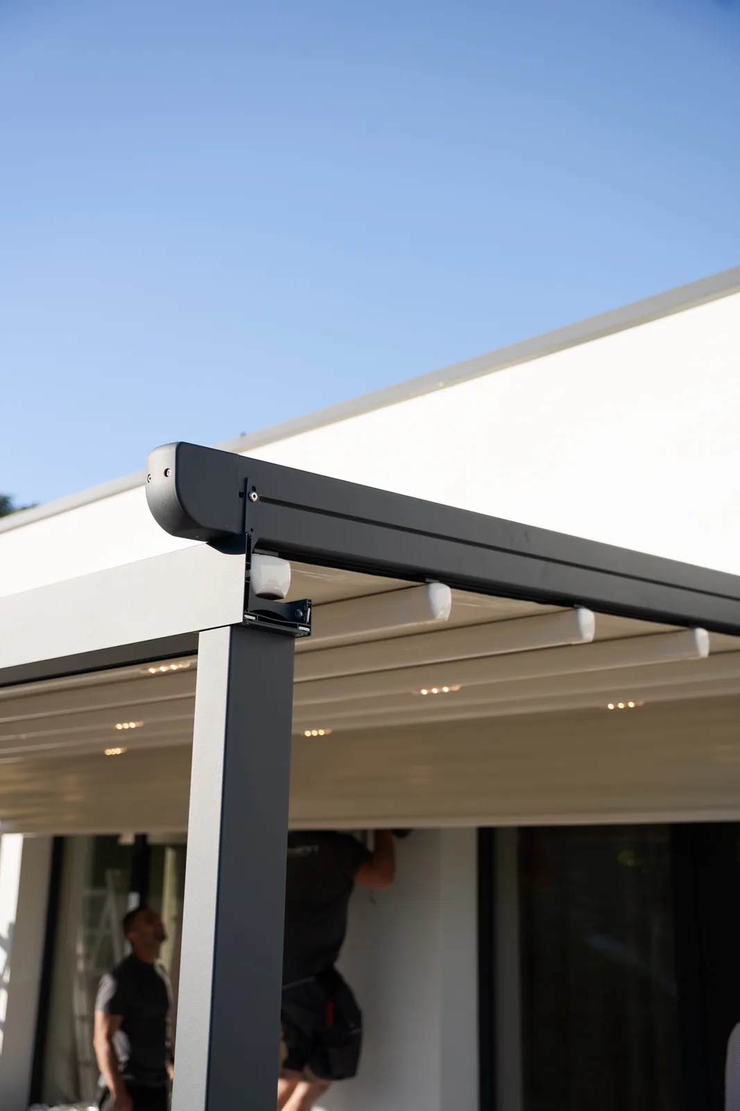 Structura antracit a pergolei retractabile PVC lipită de fațada casei din Cluj