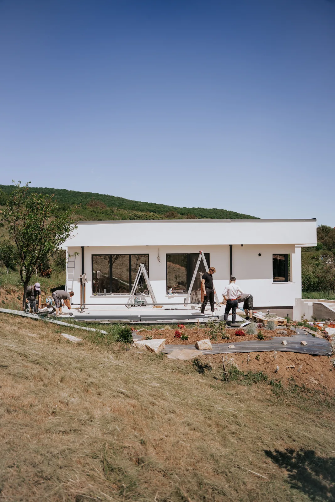 Casa din Cluj cu pergola retractabilă PVC în montaj, pe un teren în pantă