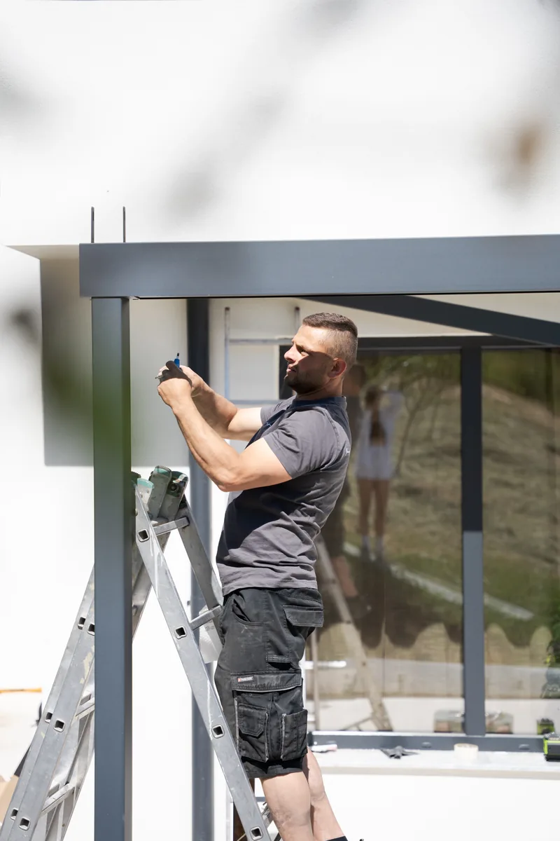 Montator HEXANN pe scară la structura pergolei retractabile PVC din Cluj